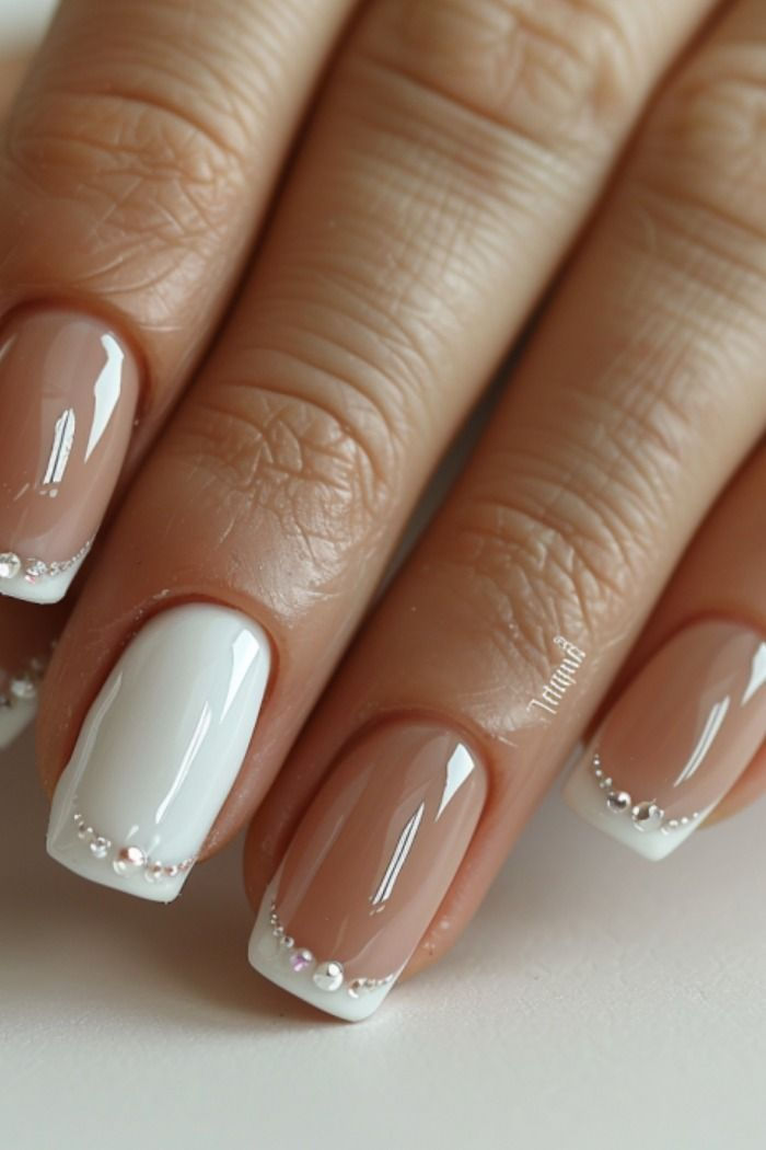 Sophisticated Nude and White Nail Design with Elegant Bead Accents