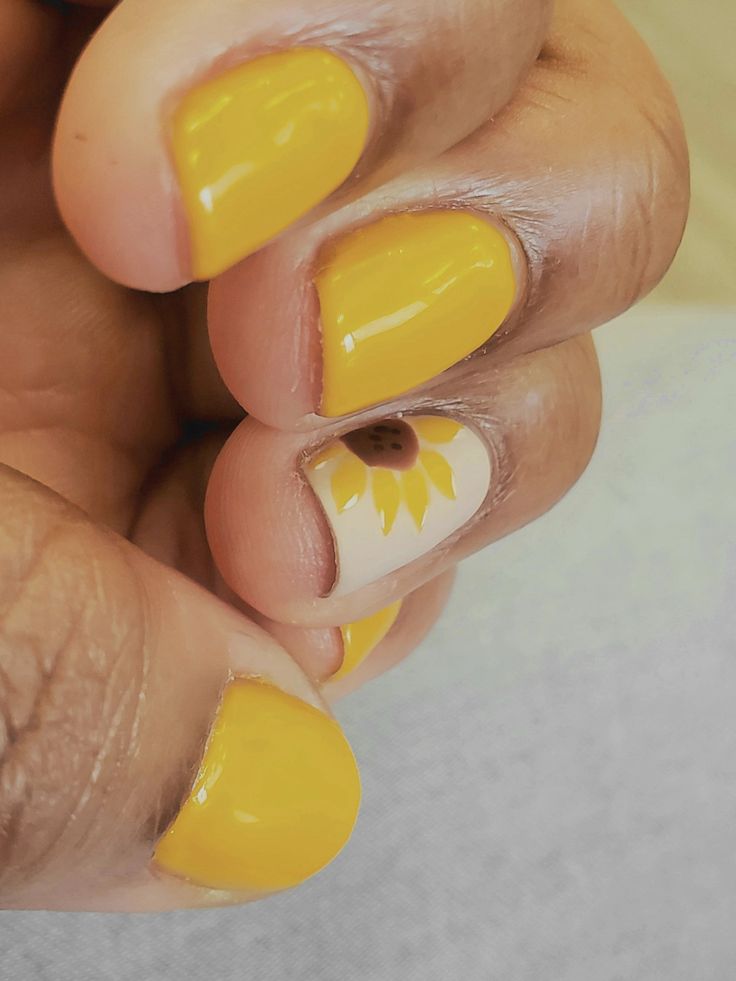 Cheerful Yellow Nail Art with Playful Sunflower Accent for a Vibrant Look.