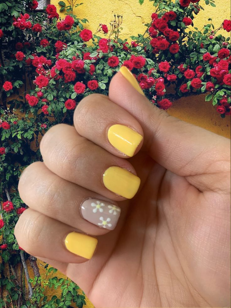 Cheerful Yellow Nail Design with Artistic Floral Accents for Spring/Summer.