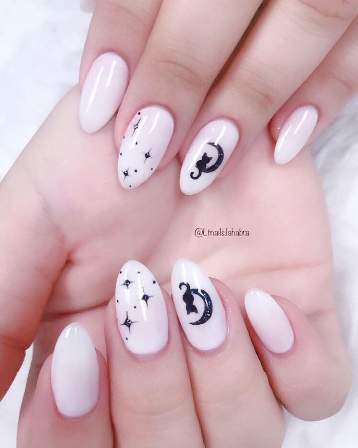 Chic Almond-Shaped Nail Design: Glossy White Base with Black Cat and Moon Motifs.