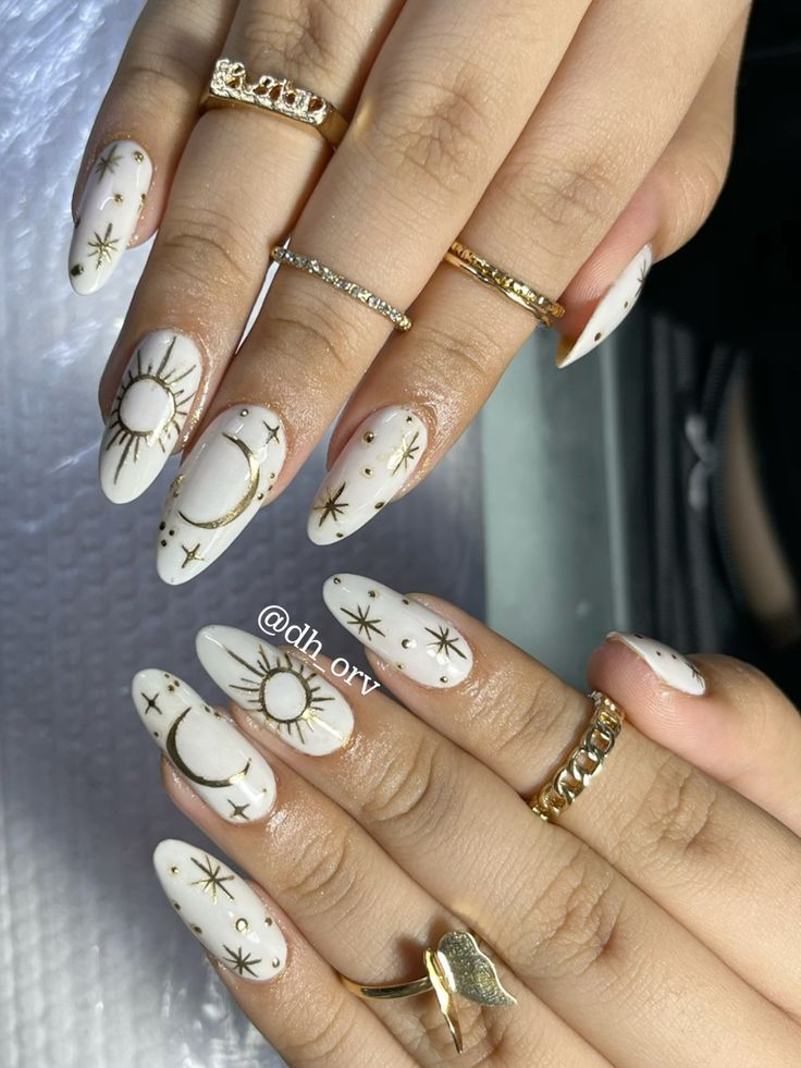 Chic Celestial-Inspired Nail Design with Gold Accents and Dainty Rings.