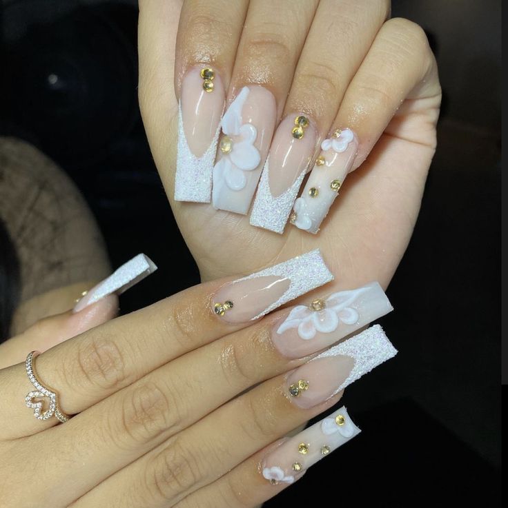 Sophisticated Elegant Nail Design: Almond-Shaped Tips with Floral Patterns and Golden Accents.