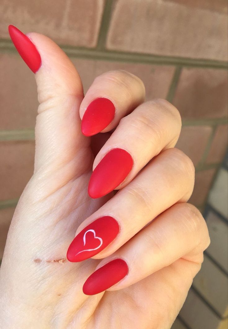 Elegant Red Almond Manicure with Matte Finish and Heart Accent.