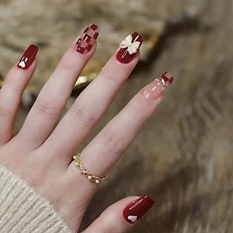 Sophisticated Red Nail Design with Intricate Patterns and Sleek Contrast for Festive Occasions.