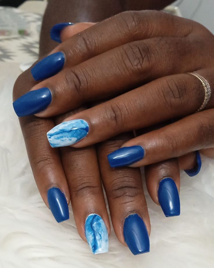 Stunning Vibrant Blue Nail Art: A Chic Fusion of Solid Shades and Artistic Marbling.