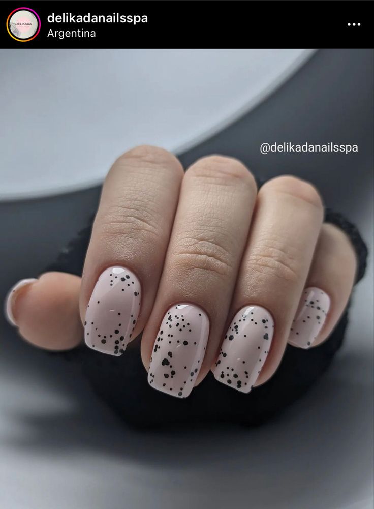 Sophisticated Nude Nail Design with Playful Black Speckles.