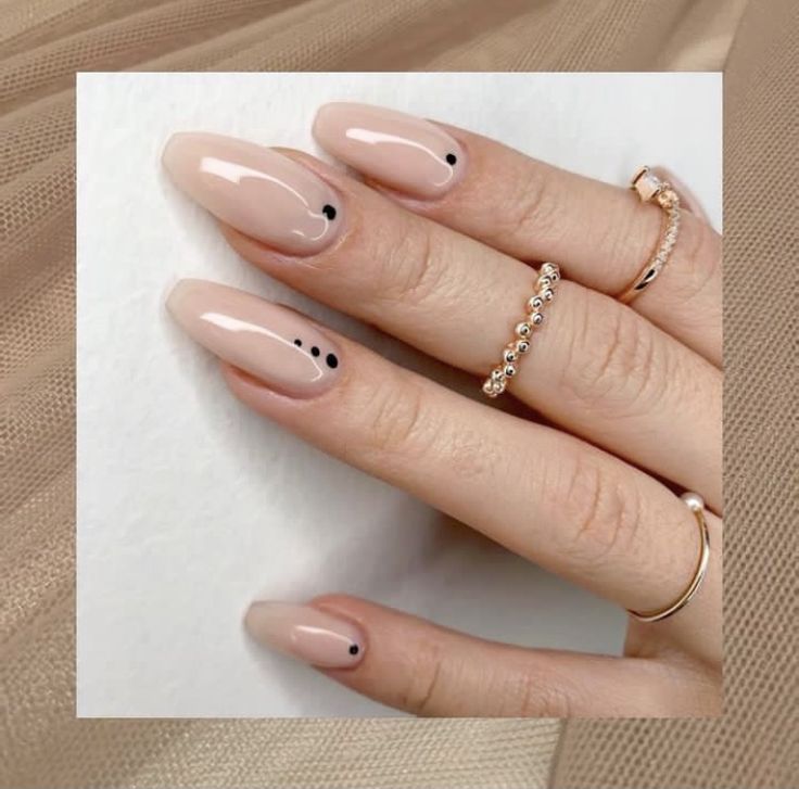 Sophisticated Elegant Nude Nails with Glossy Finish and Chic Black Dot Accents.