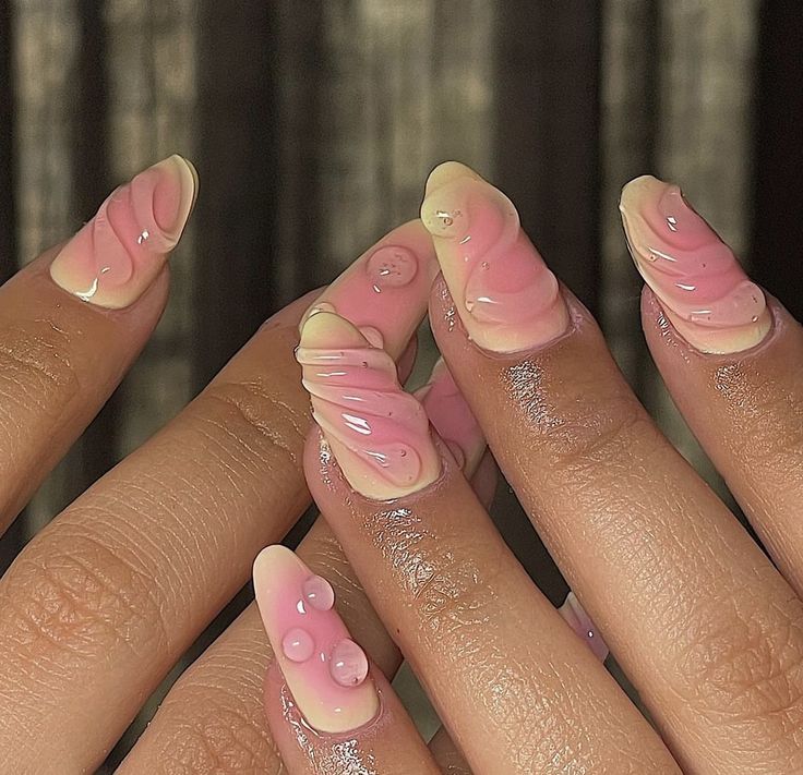 Chic Nail Design: Eye-Catching Pink and Nude Swirl with 3D Texture and Glossy Accents.