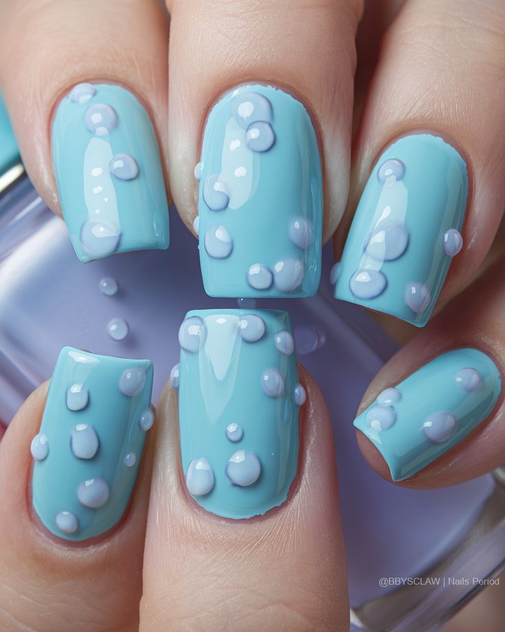 Whimsical Bubble-Inspired Nail Design: Light Blue Base with Glossy Finish and Lavender Accents.