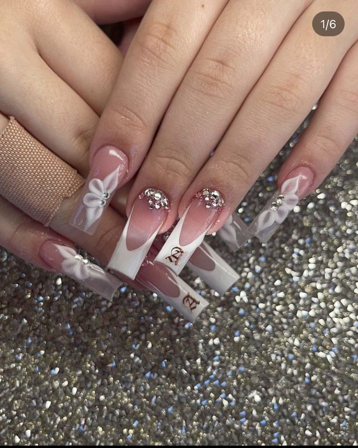 Chic Nail Design: Soft Pink and White with Glamorous Bows and Rhinestones.