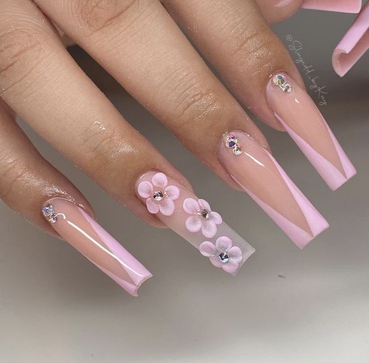 Whimsical Soft Pink Nail Design with Floral Accents and Sparkling Gems