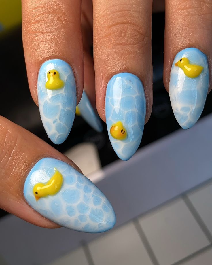 Whimsical Water-Inspired Blue Nail Design with Playful Yellow Duck Embellishments