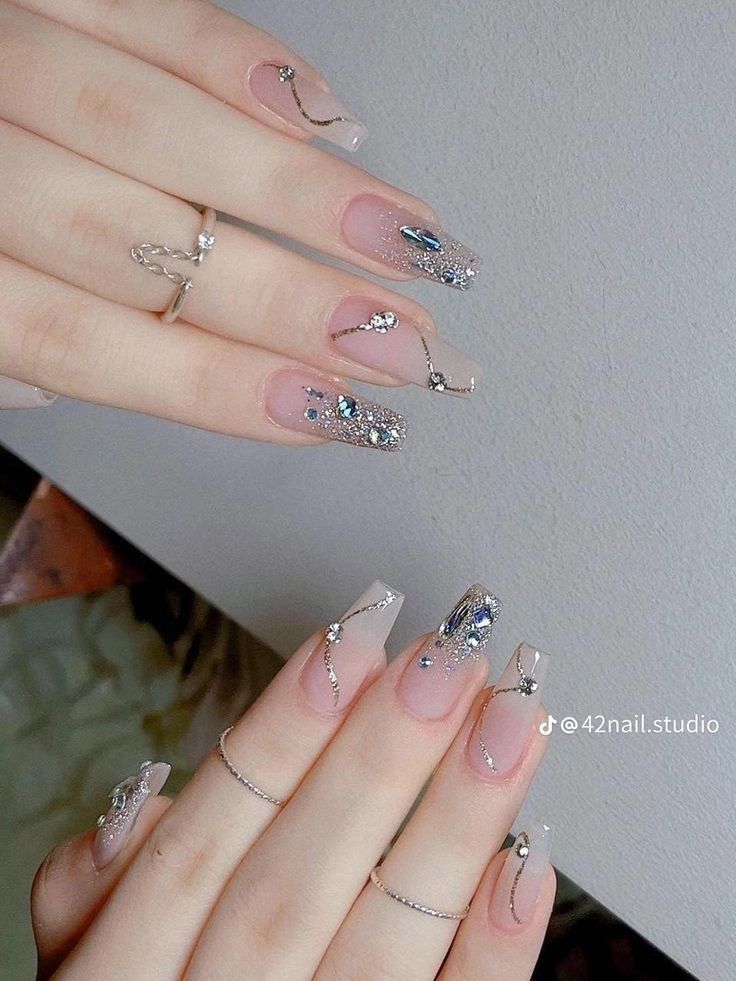 Sophisticated Nude and Glitter Nail Art with Sparkling Accents and Elegant Embellishments