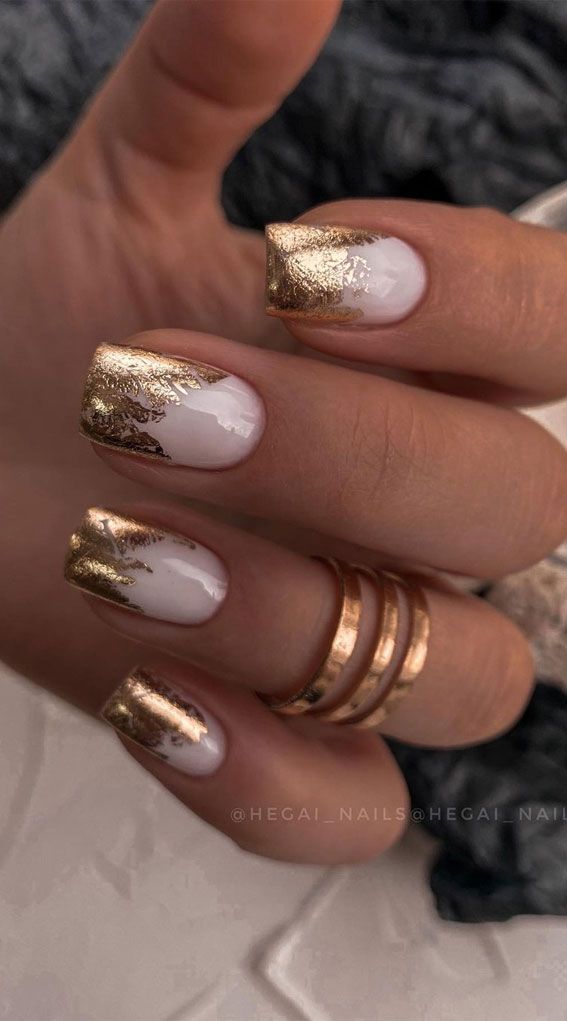 Elegant Nail Design with Striking White Polish and Intricate Gold Accents