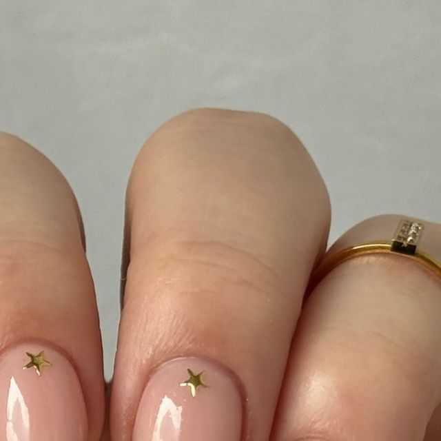 Elegant Nude Nails with Playful Gold Star Accents