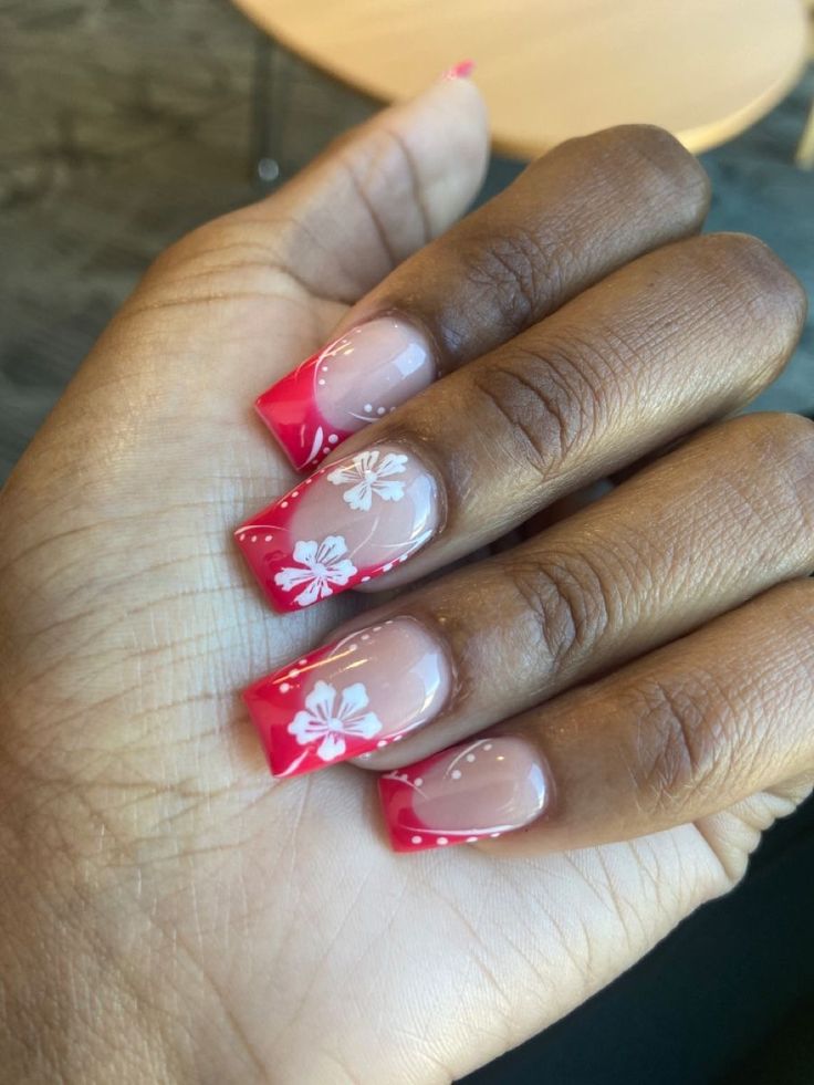 Chic Pink and Red Ombre Nails with Floral Designs for a Vibrant Seasonal Look.