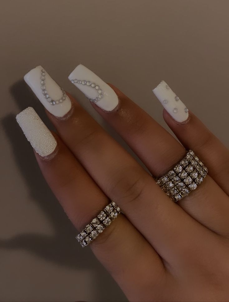 Sophisticated Elegant White Nail Design with Intricate Embellishments for Special Occasions.