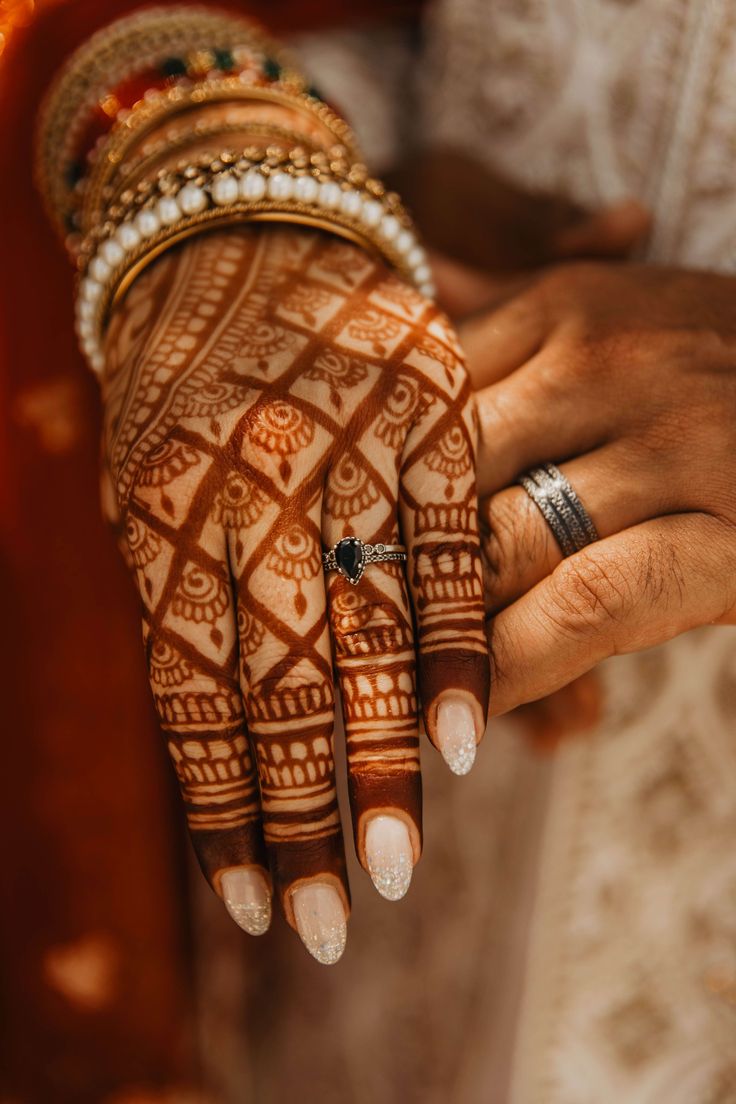 Elegant Fusion of Henna Patterns and Modern Nail Design Enhanced by Vibrant Bangles.