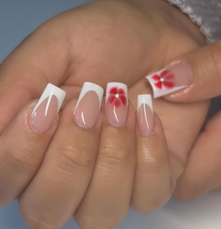 Stylish French Tip Nail Design with Soft Pink, White, and Red Floral Accents.