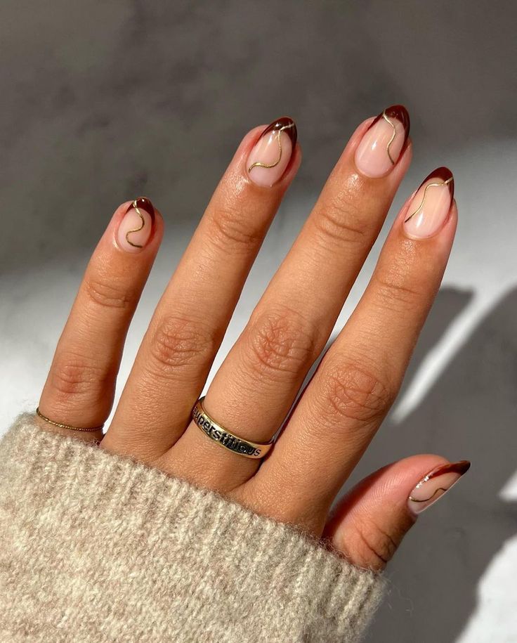 Chic Burgundy French Tip Nails with Delicate Gold Lines on a Soft Nude Base.