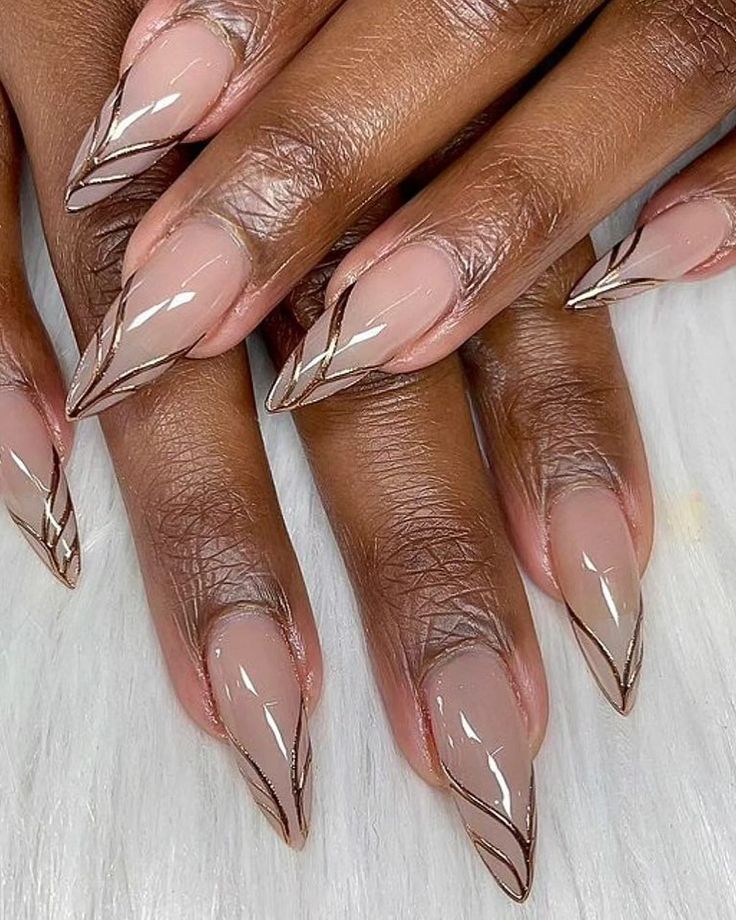 Chic Almond-Shaped Nails: Soft Nude Base Accented with Shimmering Gold Lines.