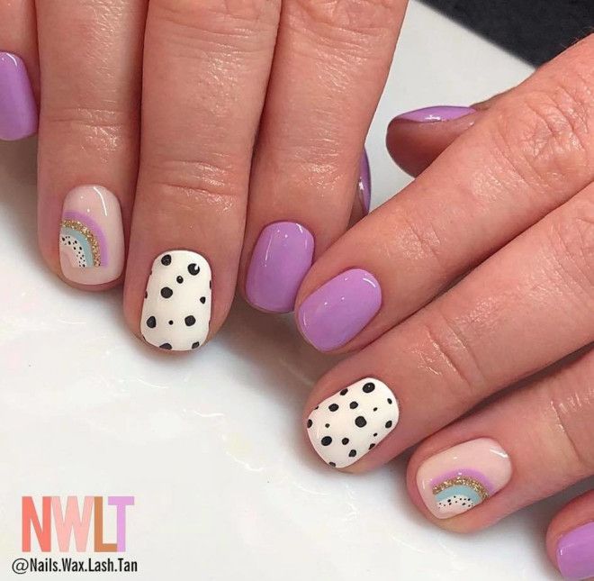 Whimsical Pastel Lavender Nail Design with Playful Polka Dots and Rainbow Accents.