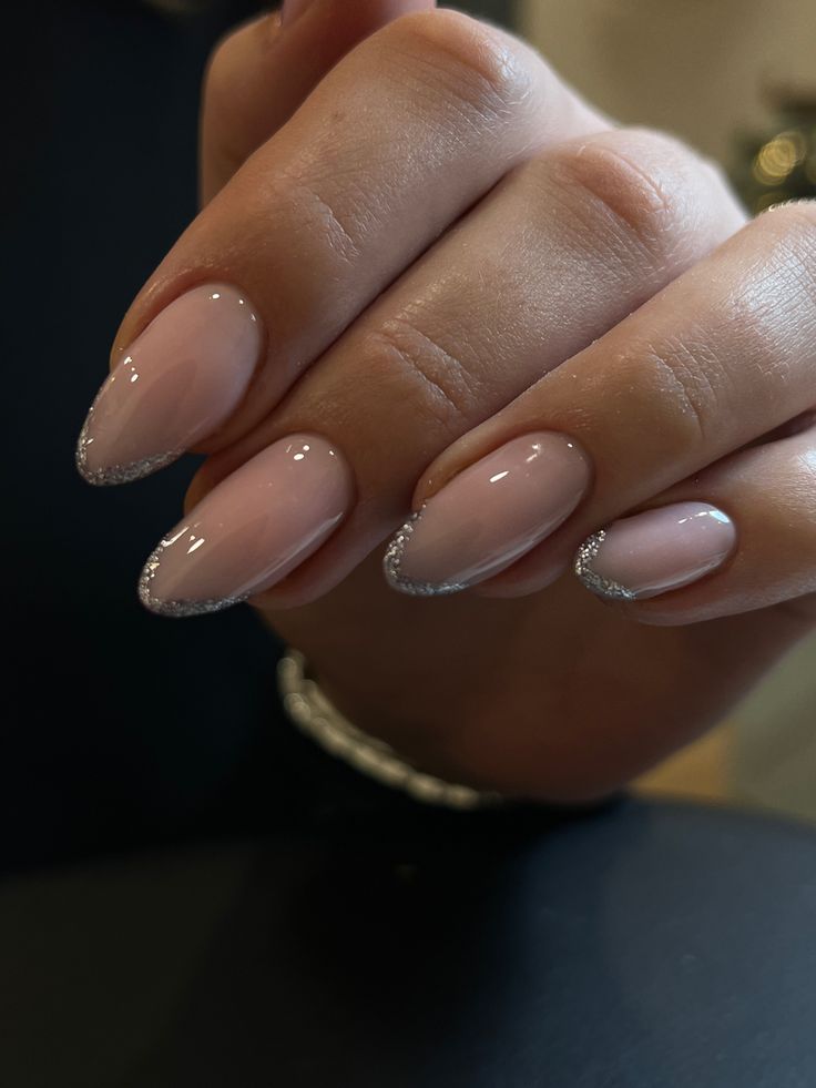 Sophisticated Almond-Shaped Nails with Soft Pink Base and Delicate Silver Glitter Tips.