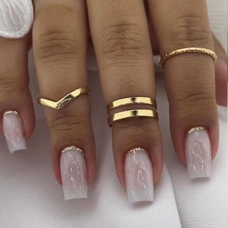 Chic Elegant Nail Design with Glossy White Tips, Marbling, and Gold Accents.