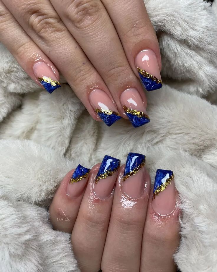 Sophisticated Glossy Nude Nails with Striking Blue Tips and Intricate Gold Zigzag Accents