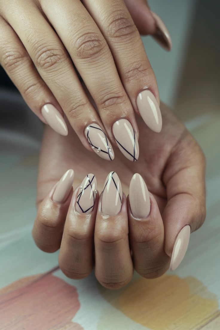 Sophisticated Almond-Shaped Nude Nails with Modern Black Geometric Patterns.