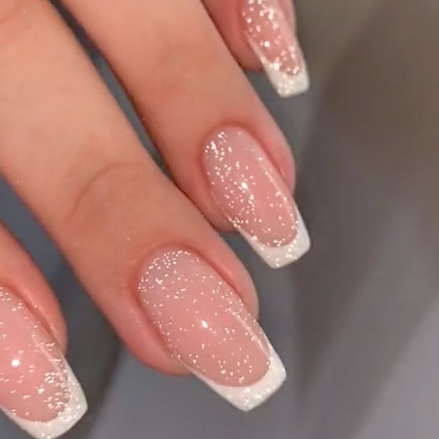 Elegant Soft Pink Nail Design with White French Tips and Sparkling Accents.