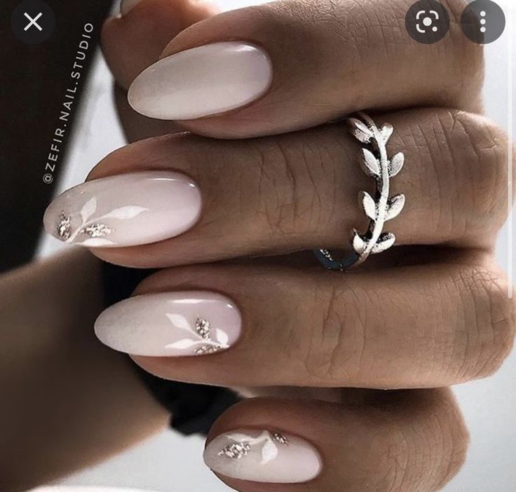 Sophisticated Pale Pink Ombre Nail Design with Floral Accents and Minimalist Silver Ring.