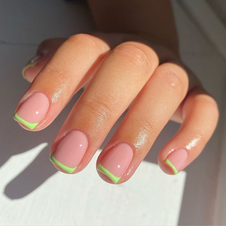 Chic Manicure: Soft Pink Base with Vibrant Green Tips for a Playful Yet Elegant Look.