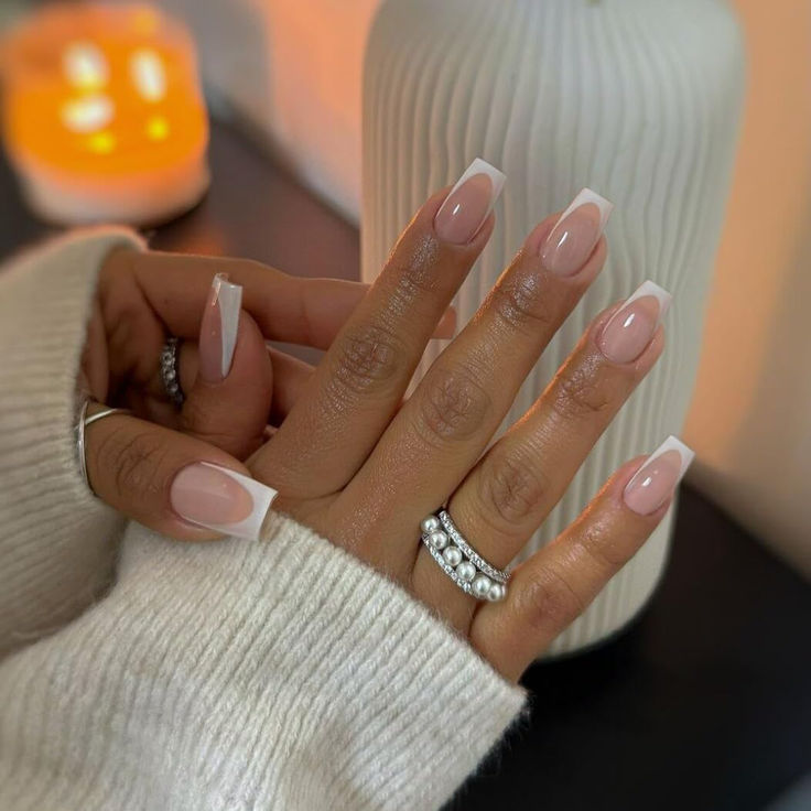 Sophisticated French Manicure: Chic Nude Base with Classic White Tips and Glamorous Accents.