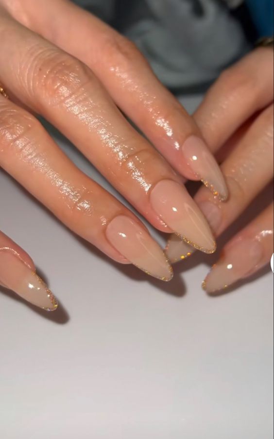 Chic Elegant Nude Nails with Subtle Gradient and Gold Accents in Modern Almond Shape.