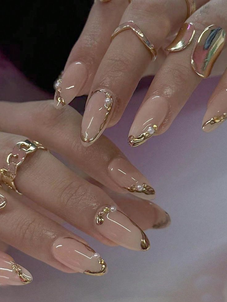 Chic Nude Nail Design with Glossy Gold Accents and Pearl Embellishments