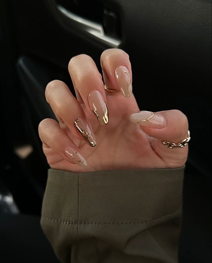 Chic Nude Nail Design with Abstract Gold Accents and Glossy-Matte Finishes