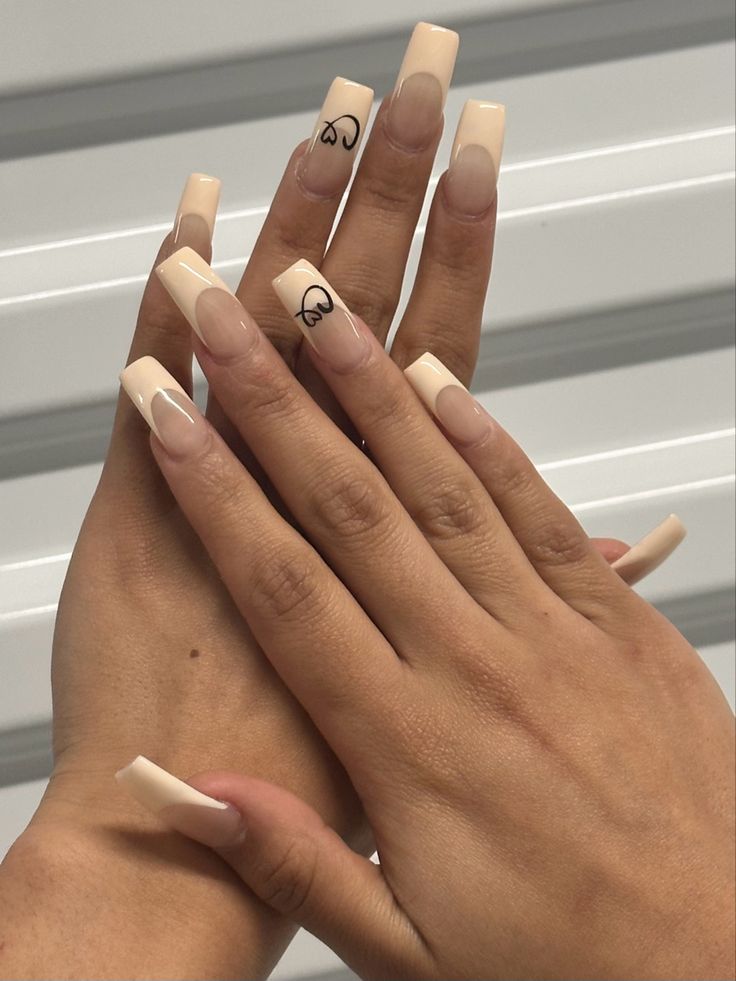 Elegant Frosted Nude Acrylic Nails with Heart Detail for a Charming Manicure.