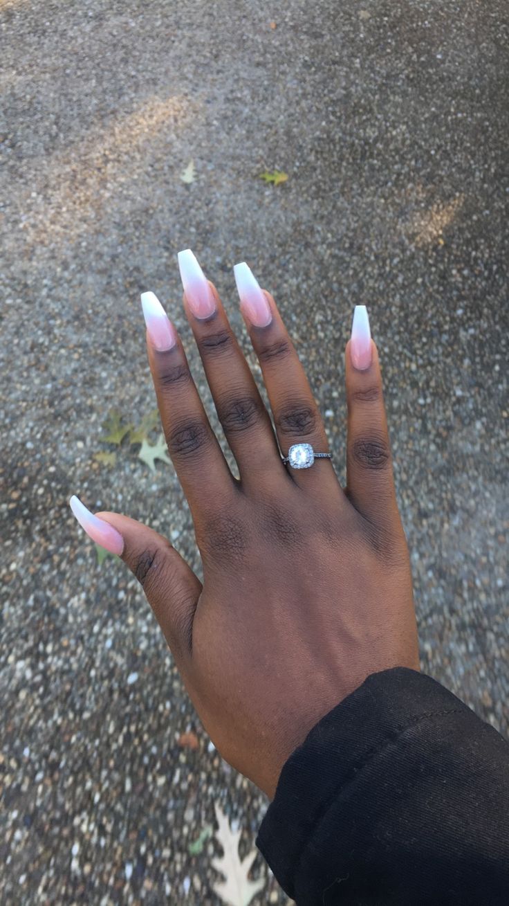 Chic Almond-Shaped Nails with Gradient Pink and White French Tips, Accented by a Stylish Ring.