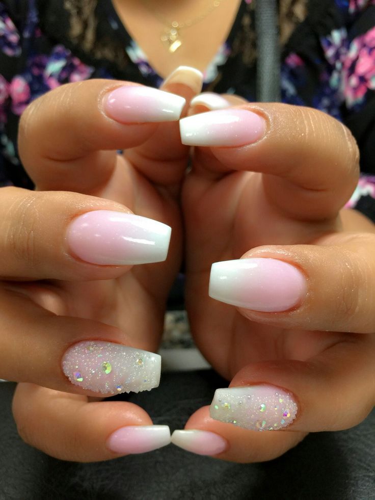 Chic Almond-Shaped Ombre Nail Design in Soft Pink and White with Sparkly Accents.