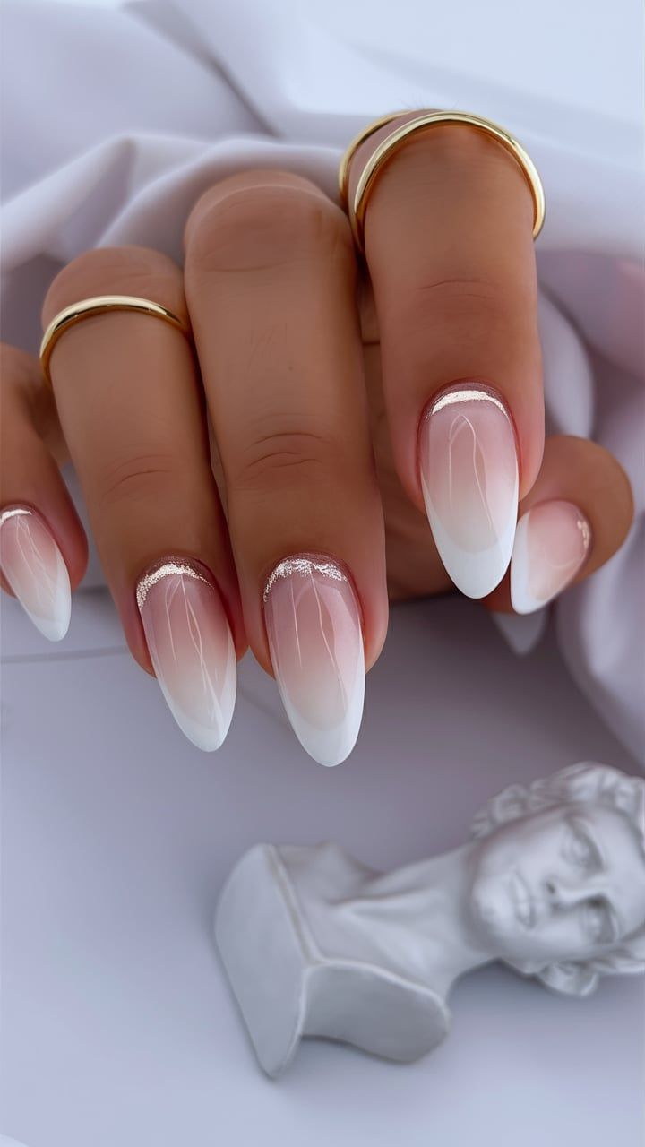 Chic Ombre Almond-Shaped Nails with Glitter Accents and Gold Ring Pairing