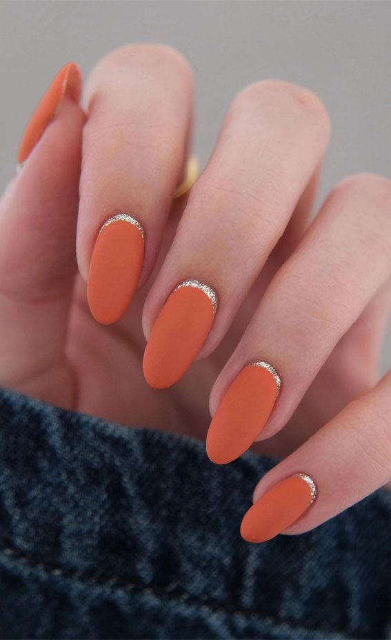 Elegant Matte Orange Almond Nails with Silver Glitter Crescent Accents