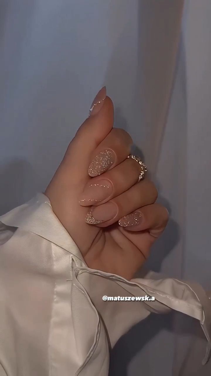 Chic Nude Nail Design with Shimmering Glitter and Subtle Oval Accents.