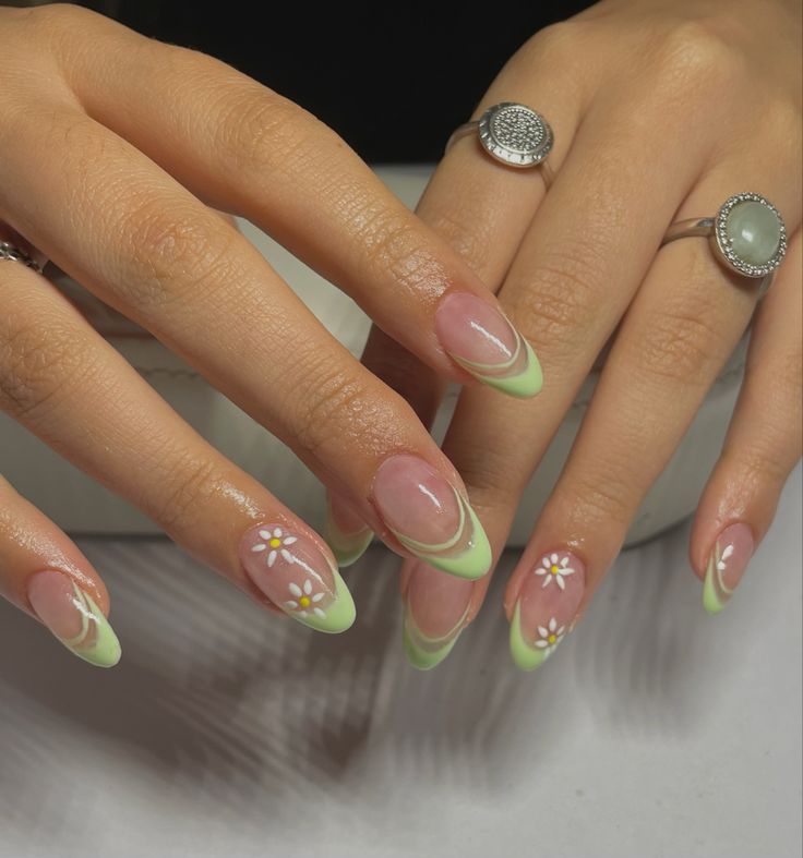 Chic Pastel Green French Tip Nails with Whimsical Floral Accents for a Fresh Spring/Summer Look.