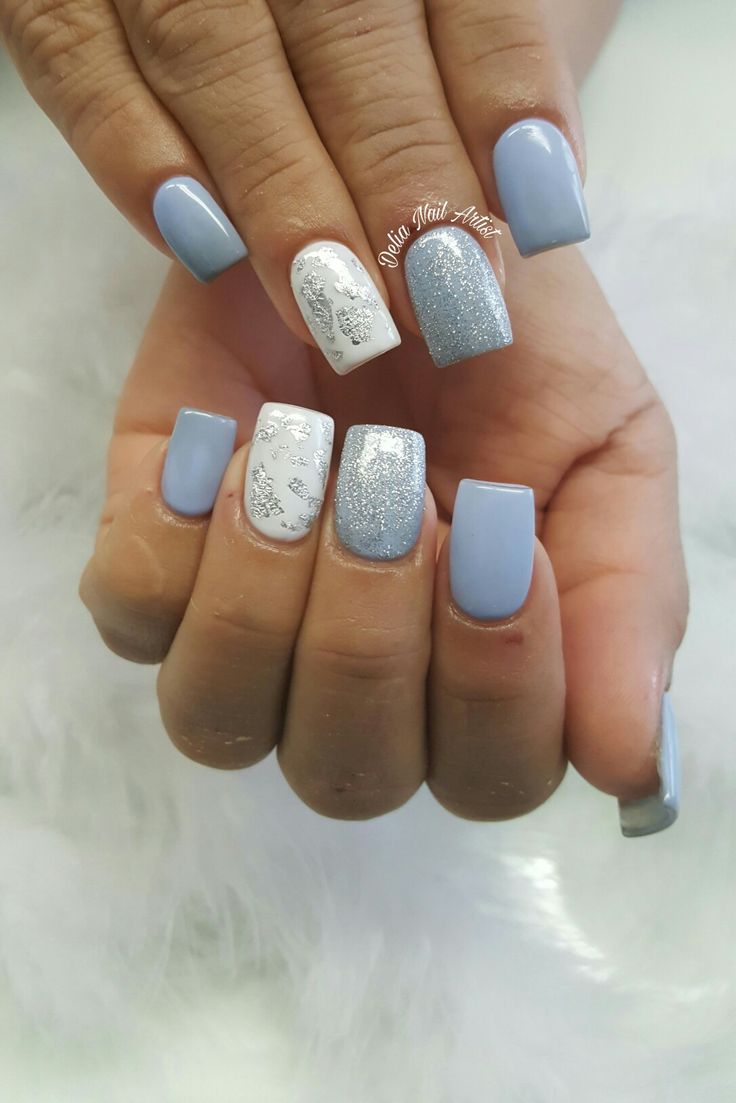 Elegant Contemporary Nail Design: Soft Blue, Shimmering Silver, and Intricate White Accents.