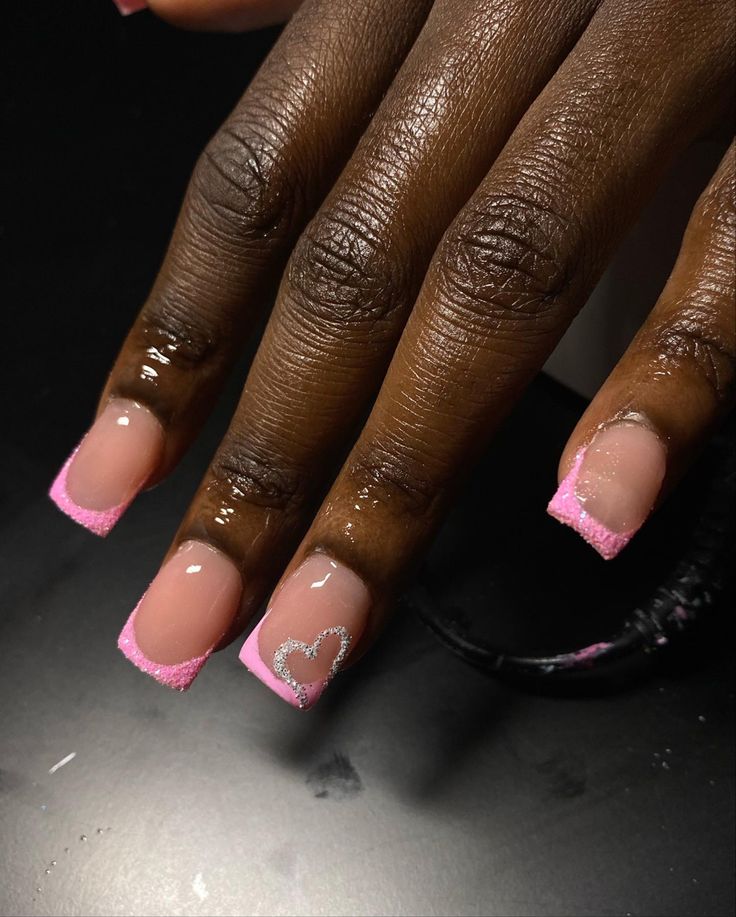 Charming Pink French Tip Nail Design with Sparkling Silver Hearts for Vibrant Occasions.