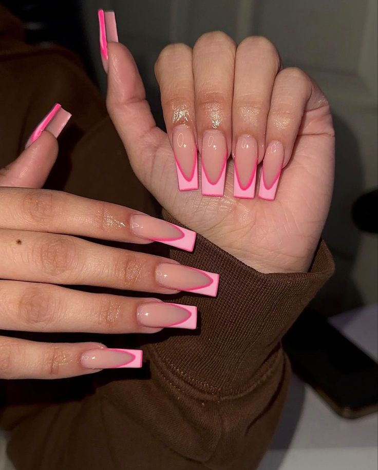 Chic Modern Nail Design: Elongated Acrylic Tips with Vibrant Pink Edges and Nude Base.