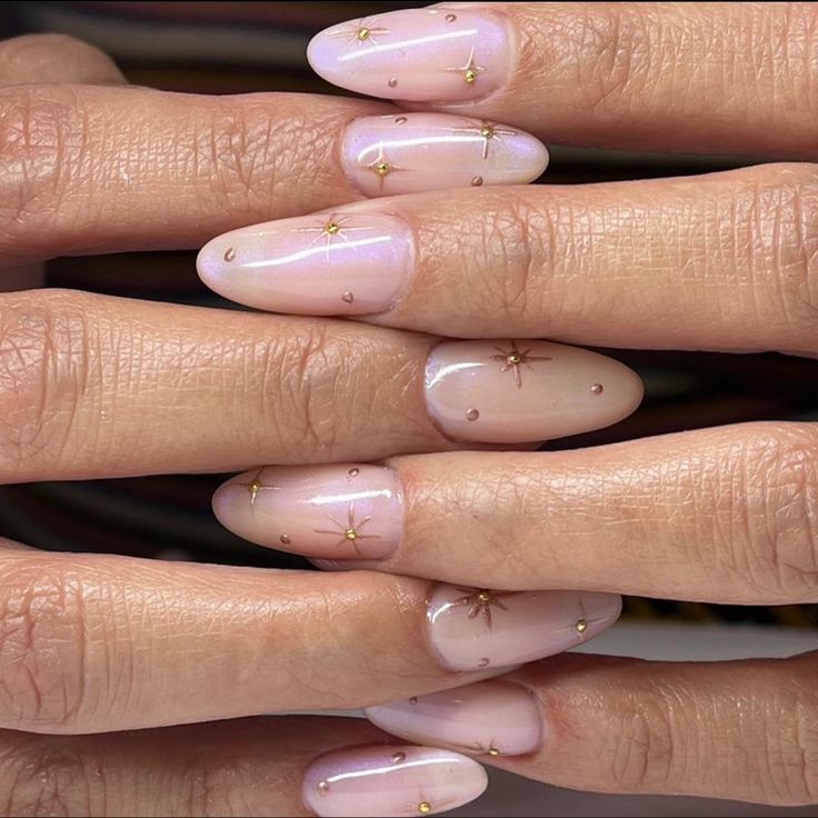 Chic Almond-Shaped Nails with Soft Pink Base and Whimsical Gold Accents