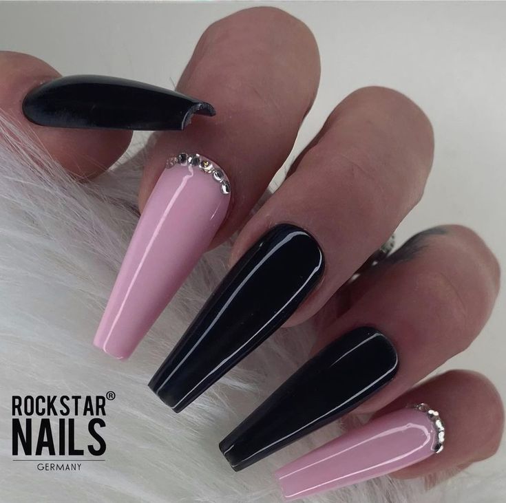 Chic Almond-Shaped Nail Design: Glossy Black and Soft Pink with Rhinestone Accents.