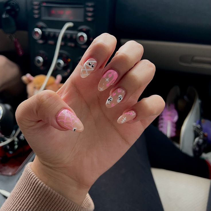 Playful Pink and Nude Nail Design with Intricate Patterns and Whimsical Accents.